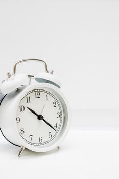 Old alarm clock with twenty minutes past ten. Date and time reminder or deadline concept, small clock on white background, counting down to holiday, vacation or end of month.Time Management