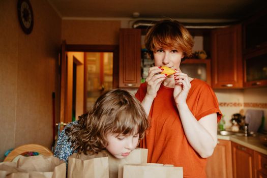 Mother and daughter with groceries in kitchen