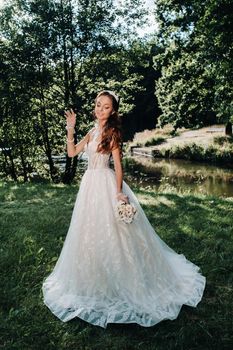 portrait of an elegant bride in a white dress with a bouquet in nature in a nature Park.Model in a wedding dress and gloves and with a bouquet .Belarus