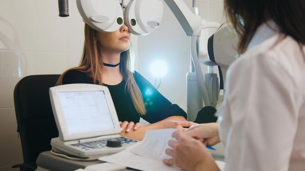 Ophthalmology - white woman checks vision in an ophthalmologist room - medicine high technology