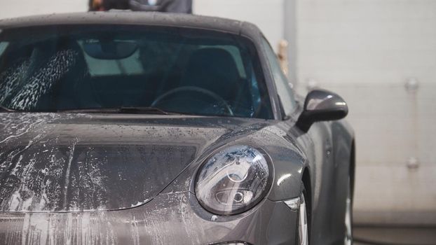 Washing automobile - sportcar in the suds by water hoses