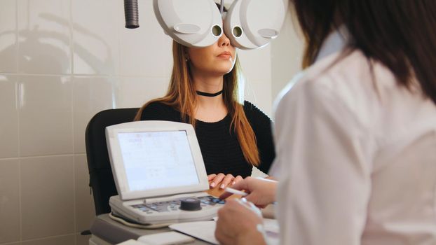Ophthalmology - eyes clinic concept - optometrist and patient doing exam vision