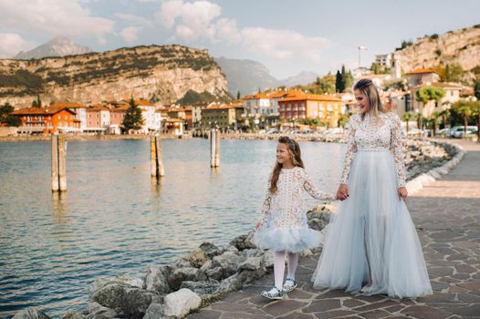 Italy, Lake Garda.Stylish Mother and daughter on the shores of lake Garda in Italy at the foot of the Alps. mother and daughter in Italy