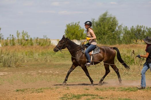 Horseback riding lessons - young woman riding a horse
