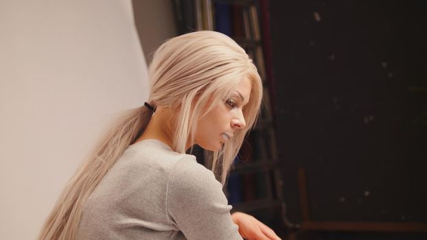 Blonde model posing for photographer at studio