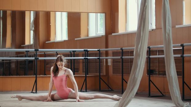 Teen sport - model girl acrobatic sits on a splits