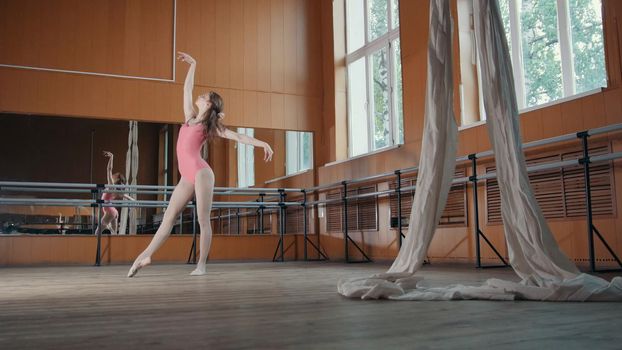 A young girl gracefully performs acrobatics tricks in studio