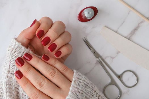 Stylish red female nails. Modern Beautiful manicure. Autumn winter nail design concept of beauty treatment. Gel nails. Skin care.