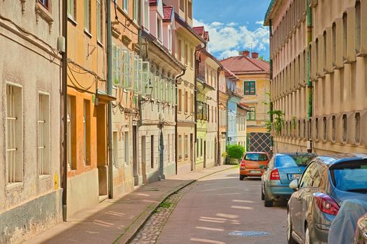 Ljubljana - June 2020, Slovenia: View of a narrow street with colorful apartment buildings and parked cars