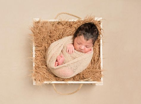 Lovely hairy baby resting in a basket