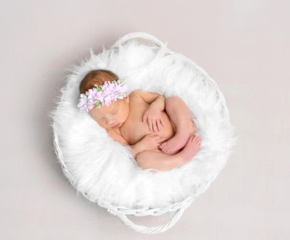 Baby girl with a hairband sleeping naked, topshot