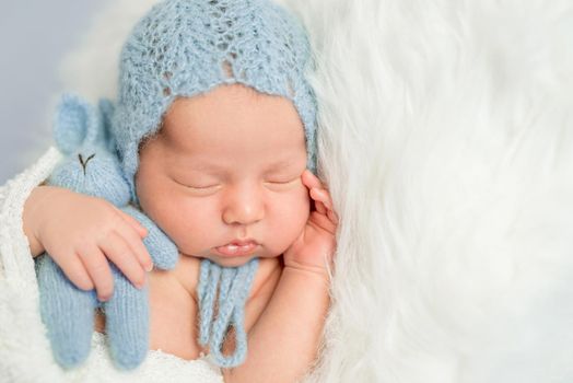 sleepy newborn boy in blue hat