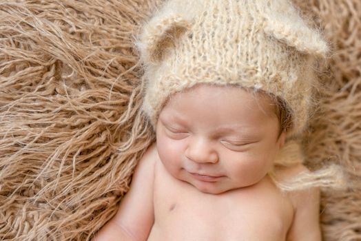 asleep smiling newborn baby in hat