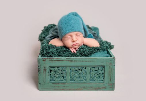 Newborn baby lying in wooden crate