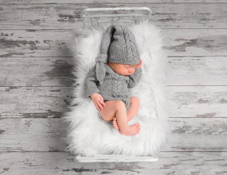 Infant in a knitted gray suit, topview