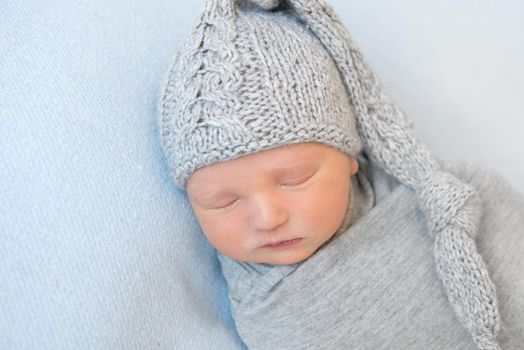 Adorable baby with knitted gray hat, napping