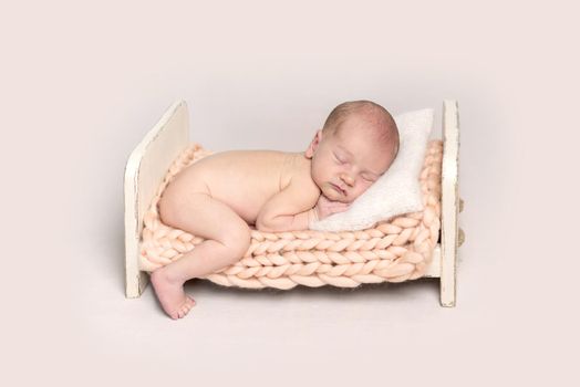 Infant baby lying on a small crib