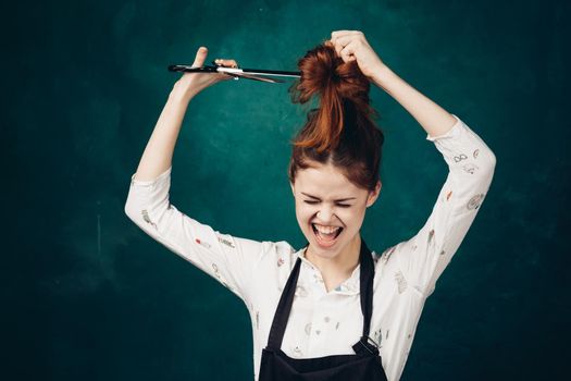 emotional woman in black apron scissors cuts her hair