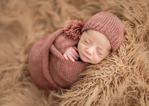 Newborn in knitted blanket