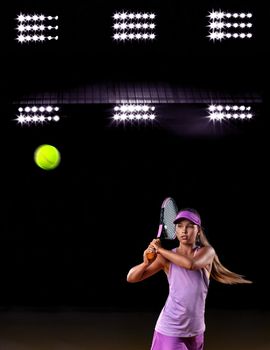 Portrait of kid - tennis player. Beautiful girl athlete with racket in pink sporswear and hat on tennis court. Fashion and sport concept.
