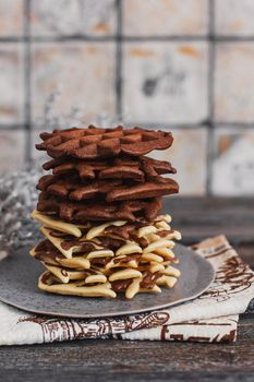 Traditional Belgian waffles with cocoa on wooden background, homemade healthy breakfast.
