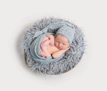 newborn sleeping curled in his wrap, topview