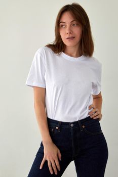 Cute woman in casual outfit standing in studio