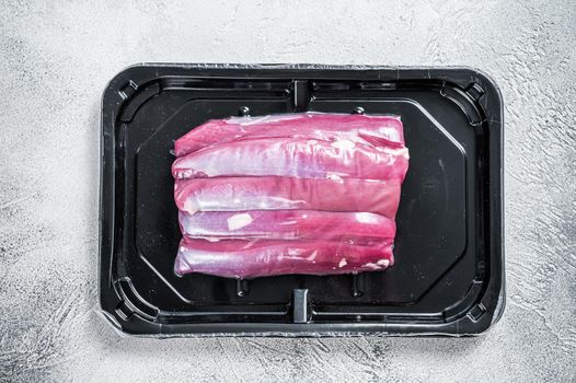 Raw lamb tenderloin in vacuum packaging. White background. Top view