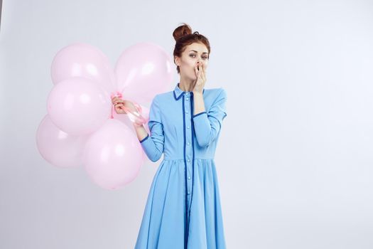 cheerful woman in a blue dress pink balloons holiday birthday. High quality photo