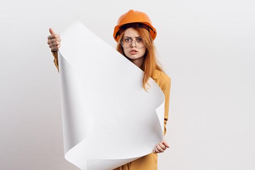 female engineer in orange hard hat blueprints architect