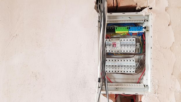 Electrical safety in homes, switchboard panel with switches. Home electrical system in the apartment under repair. Circuit breakers with wires in an electric screen with copy space.