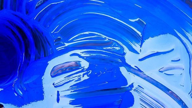 Abstract background of spilled blue paint with buckets on a black background. Blue paint is pouring on a black background. Use it for an artist or creative concept. Paints spilled blue background