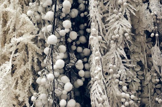 Christmas holiday decorations. Christmas tree brunch in white silver snow and ice snowflakes sparkling close up texture. Shallow focus. Christmas wallpaper concept