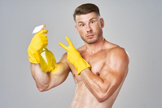 male naked torso wearing rubber gloves cleaning supplies housework isolated background