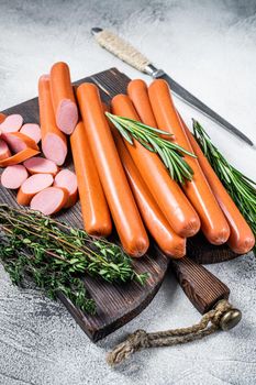 German raw Frankfurter sausages on a wooden board. White background. Top view