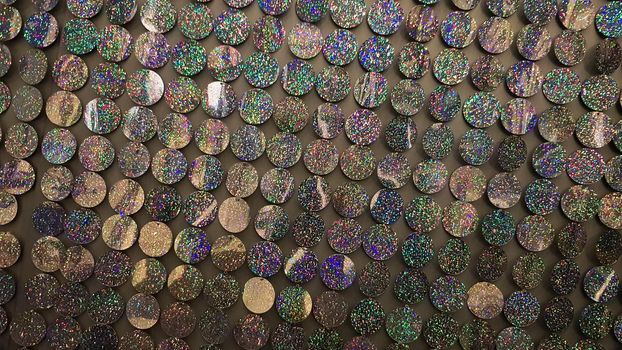 Macro close up of sparkles. Abstract background with gray sparkles. Texture scales of round spangles with color transition. Sequin background. Template for design. Festive background.