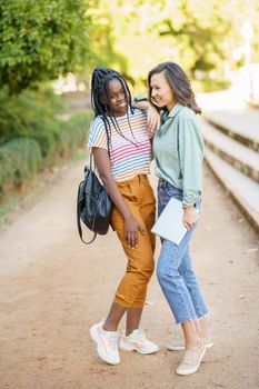 Two multiethnic girls posing together with colorful casual clothing