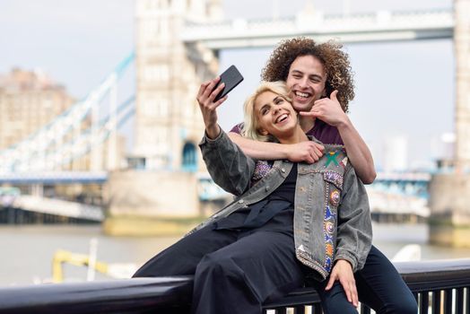 Young couple taking selfie photograph at the Tower Bridge