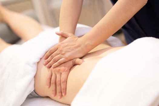 Young woman receiving a back massage in a physiotherapy center