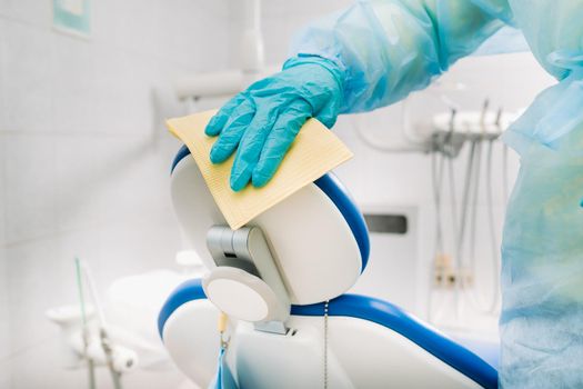 A nurse disinfects work surfaces in the dentist's office.