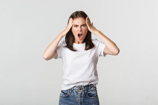 Mad and frustrated young woman looking shocked at camera
