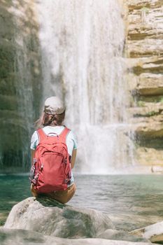Backpacker woman looking at waterfall.