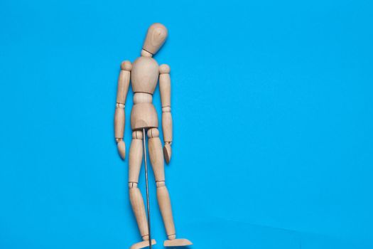 wooden figure mannequin object posing blue background