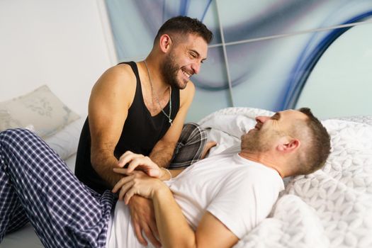 Gay couple tickling each other in bed