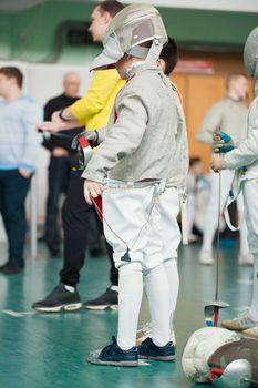 Young participant of the fencing tournament with rapier in his hands