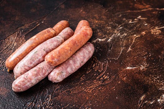 Raw barbecue sausages Chorizo and Bratwurst with spices. Dark background. Top View. Copy space