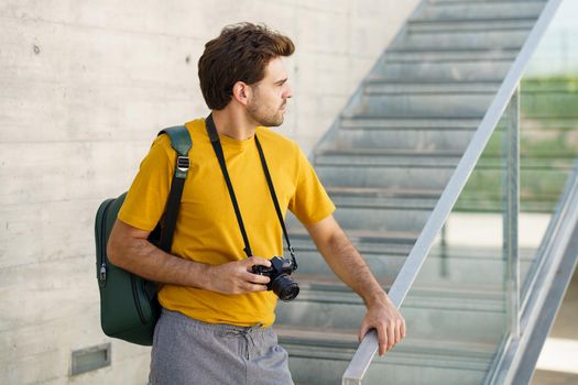 Millennial man taking photographs with a SLR camera