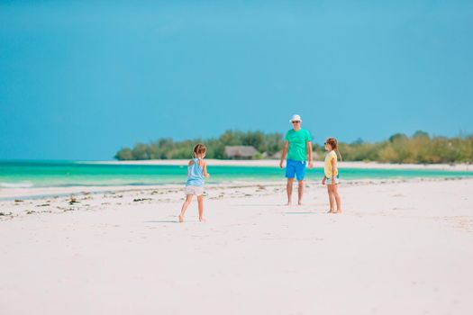 Father and little kids enjoying beach holidays