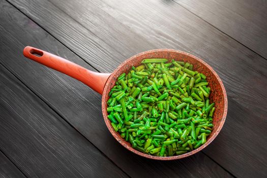Vegetarian food. Fried string beans in a pan. Stylish background for design. Minimalism. Healthy food from vegetables.