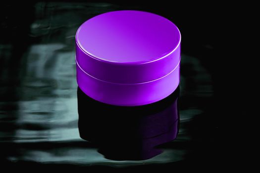 Purple plastic jar in the water on a dark background. Layout for advertising cosmetics and body care products.